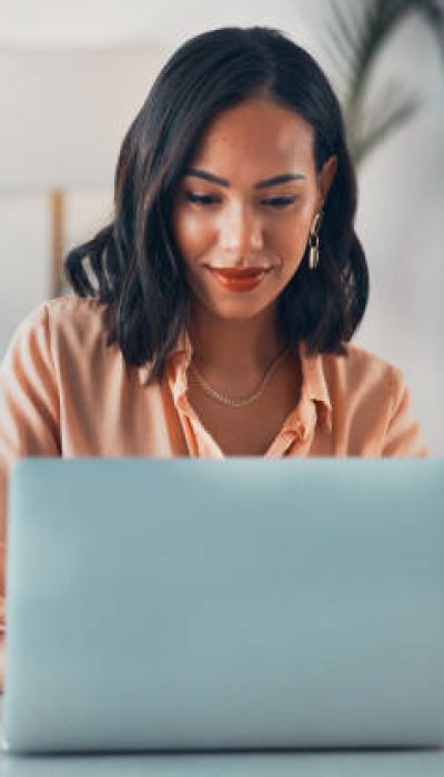 Woman working on laptop online, checking emails and planning on the internet while sitting in an office alone at work. Business woman, corporate professional or manager searching the internet